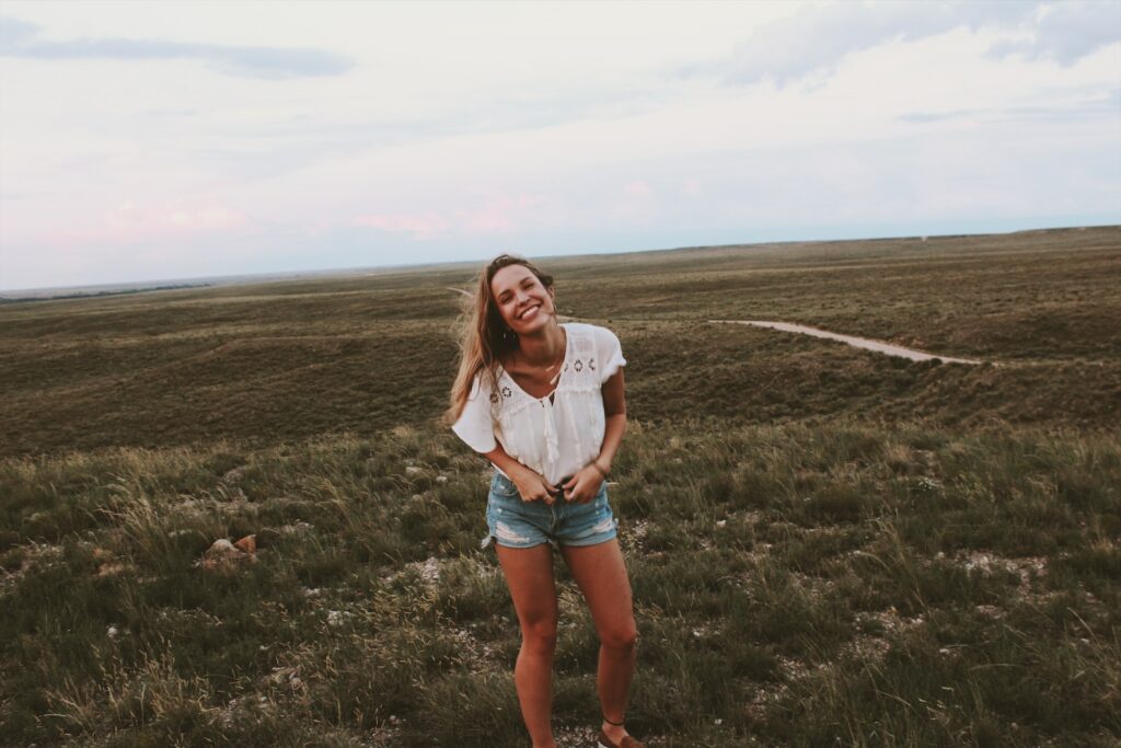 woman in white shirt standing on green grass field