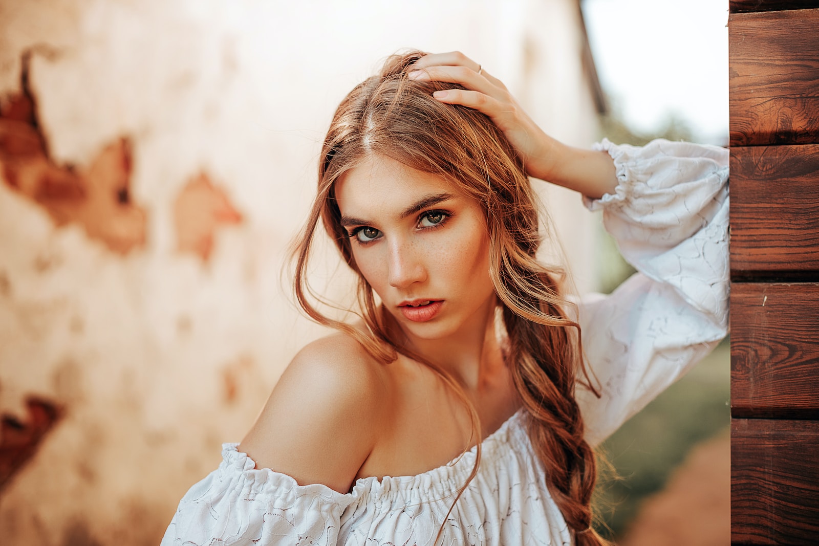 a woman with long hair wearing a white top