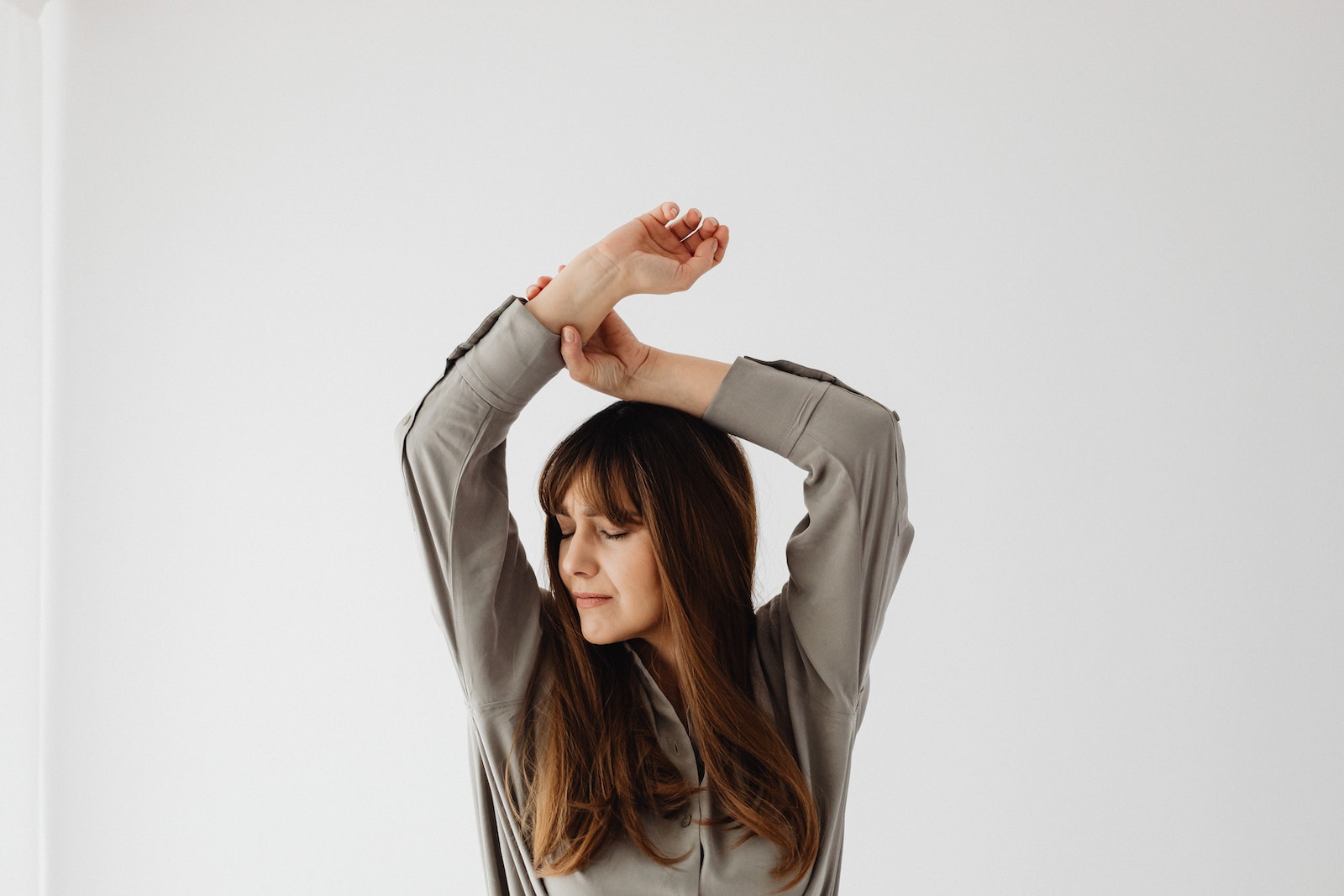 Brunette Woman with Her eyes Closed and Arms Raised