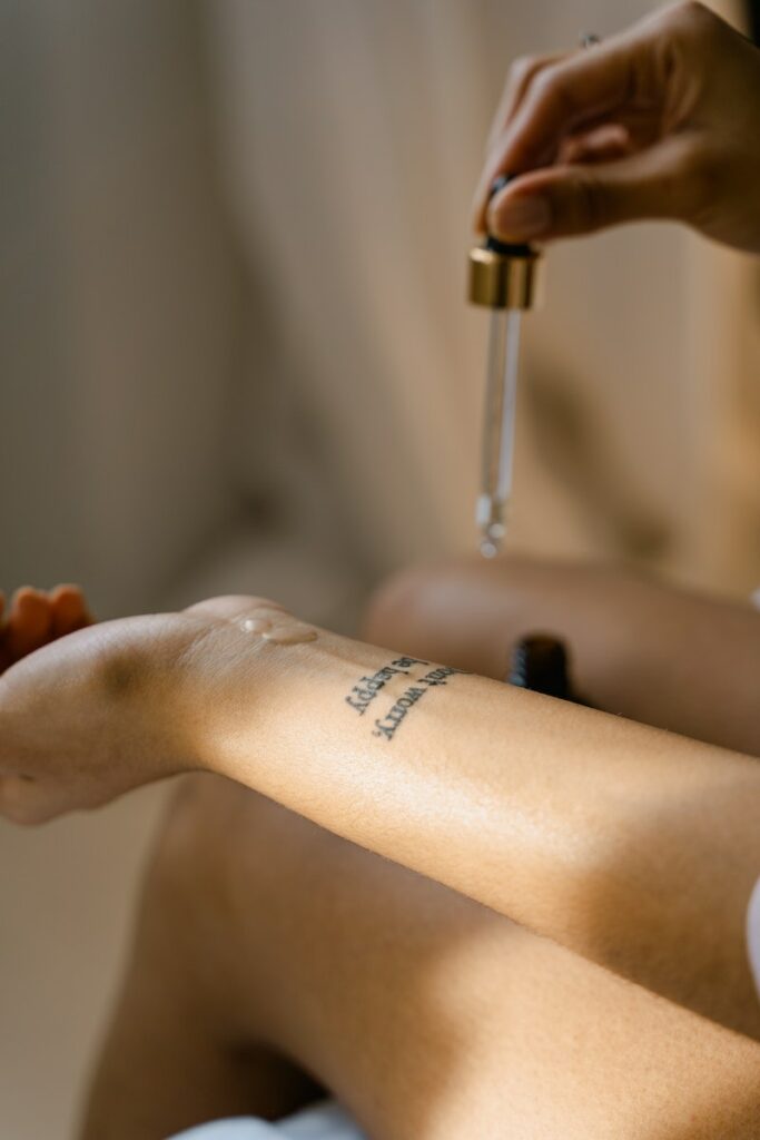 A Person Applying Oil Using a Dropper Pipette