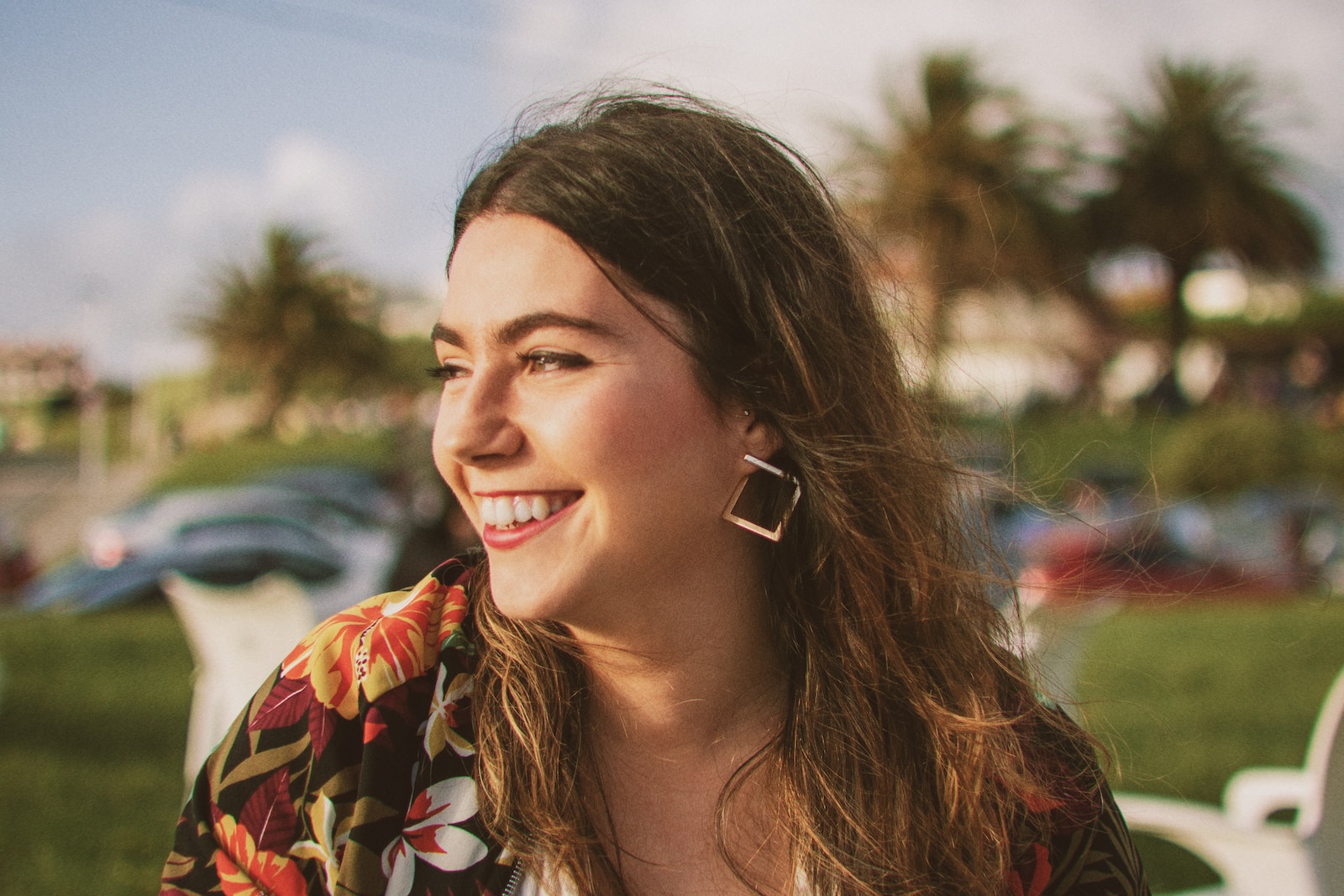 smiling woman wearing black and orange floral top