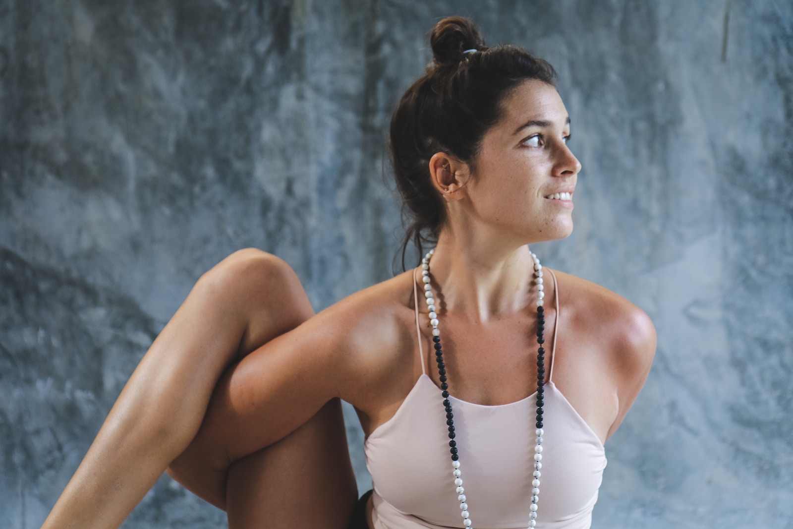 woman in white tank top and white beaded necklace