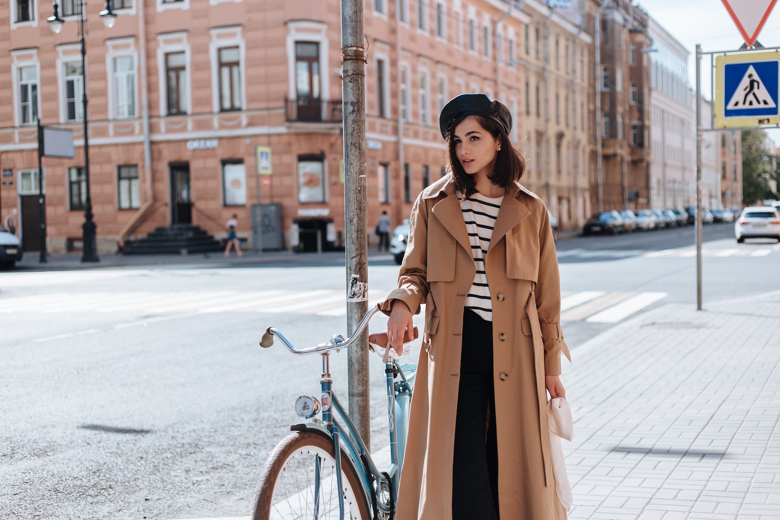 A Woman Standing on the Street Near Her Bicycle