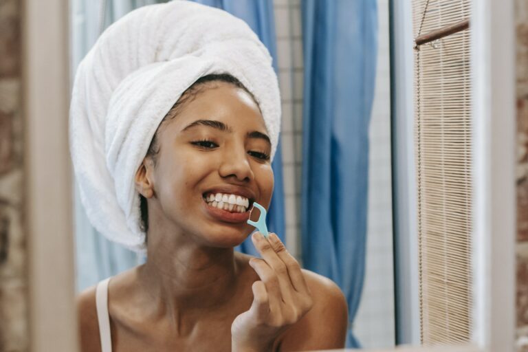 Ethnic woman cleaning teeth with dental floss