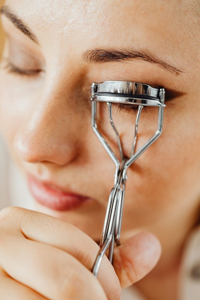 A Woman Using Eyelash Curler