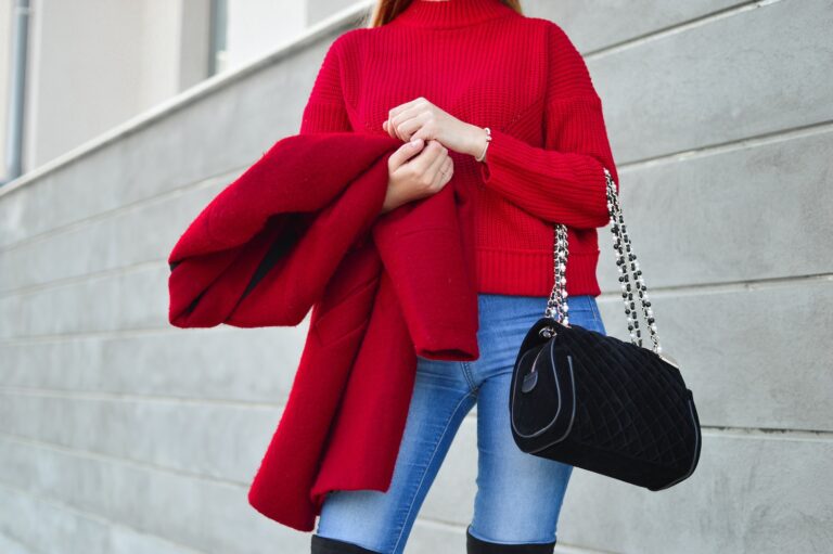 woman in red sweater beside white wall
