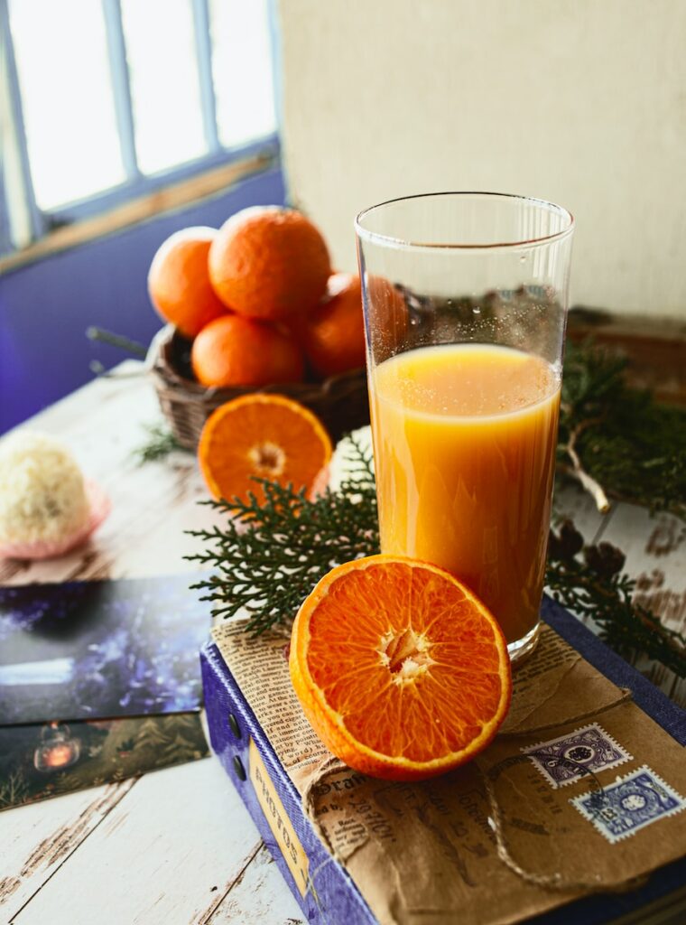 a glass of orange juice sitting on top of a book