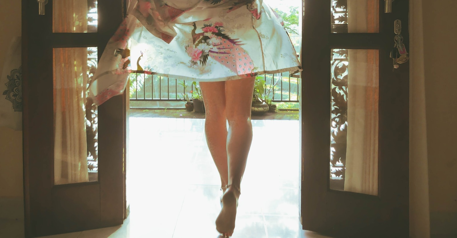 woman in white and pink floral dress standing on white floor tiles