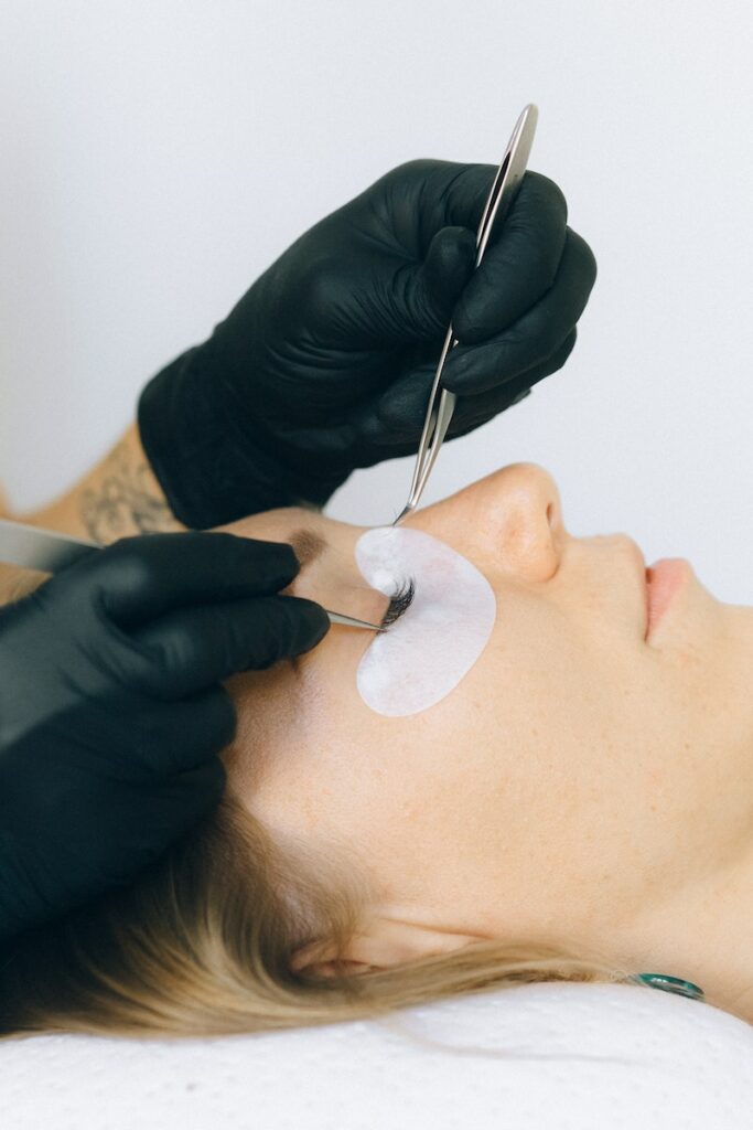 Person Working on Eyelash of a Woman