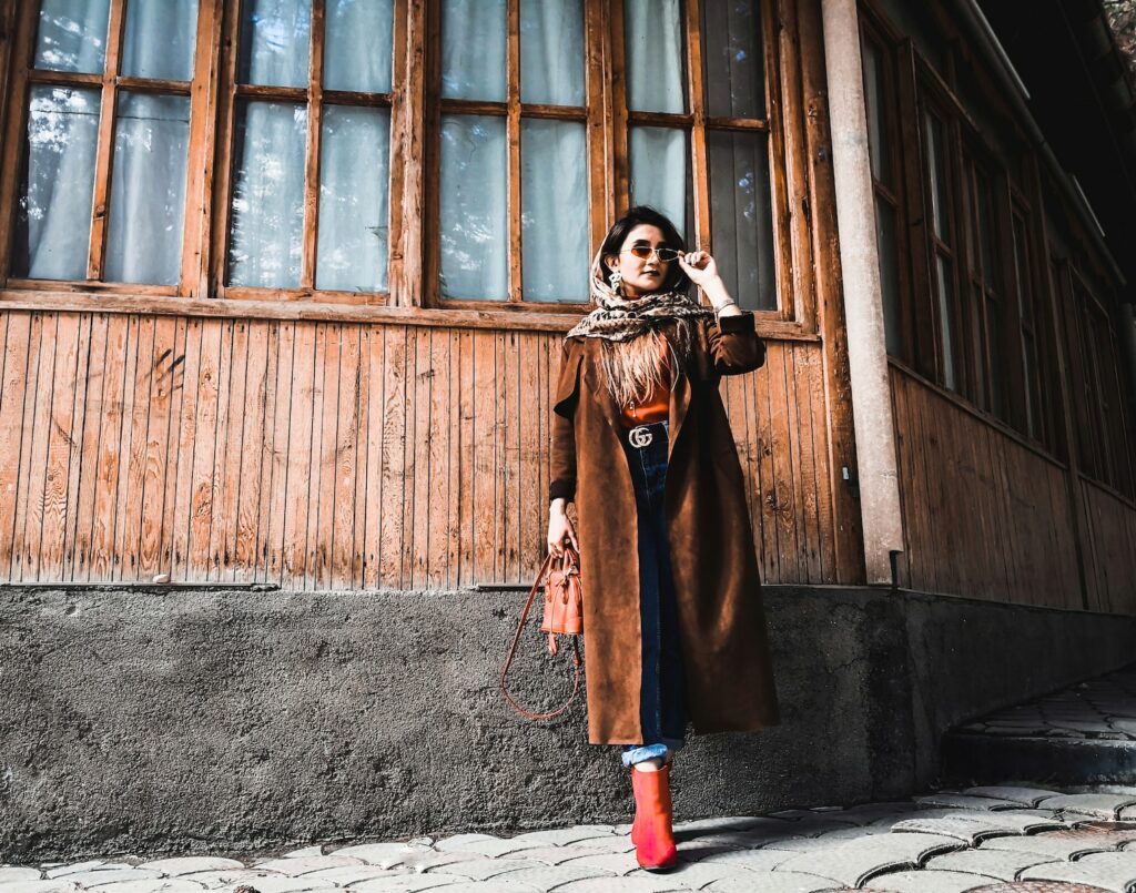 woman in brown coat standing in front of brown wooden door