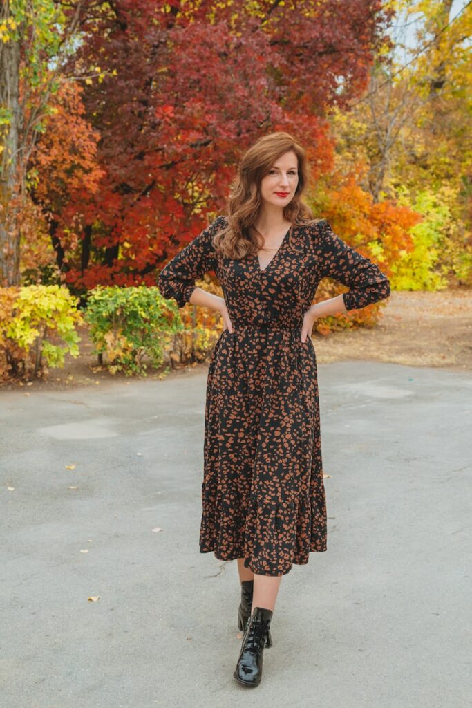 woman in black and white floral dress standing on gray concrete floor