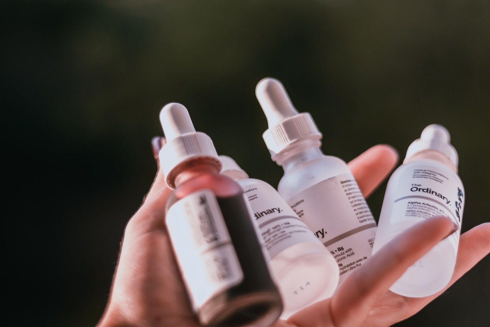 person holding white and black labeled bottles