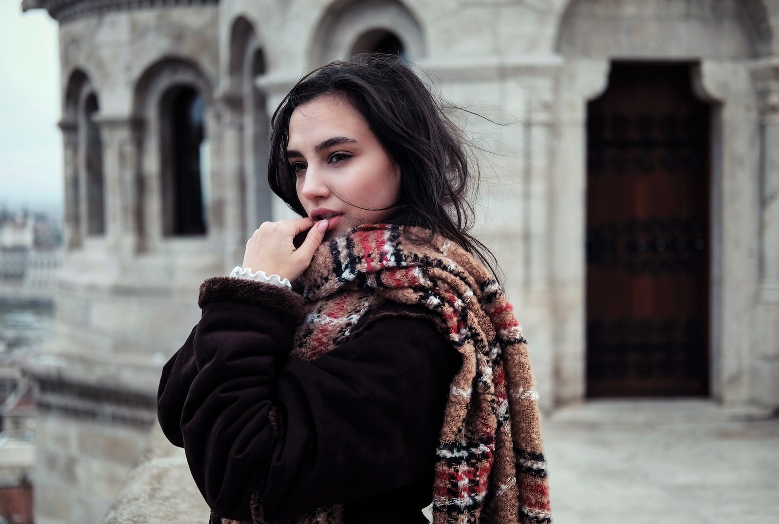 selective focus photo of woman standing near chapel