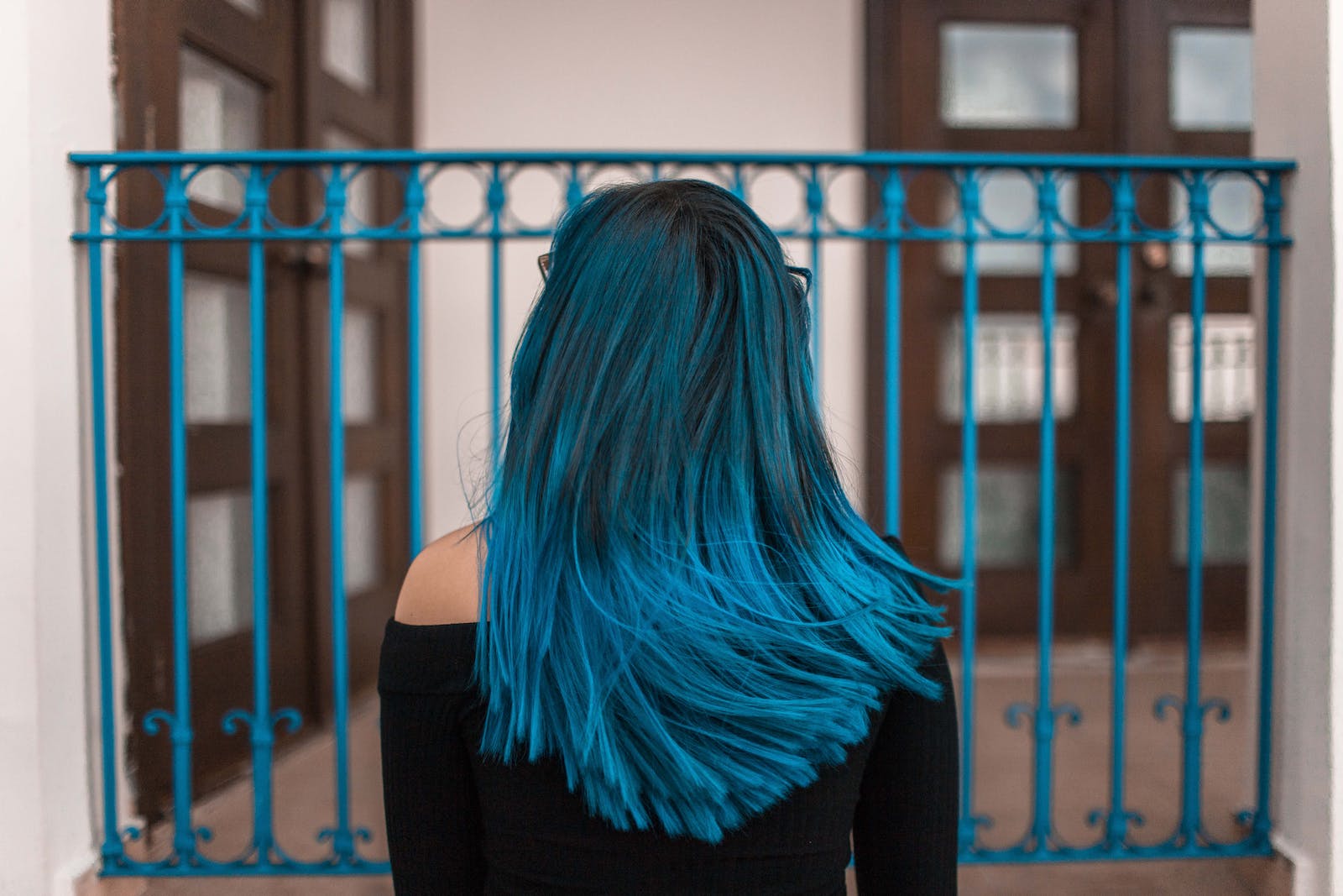 Blue Haired Woman Facing Metal Fence