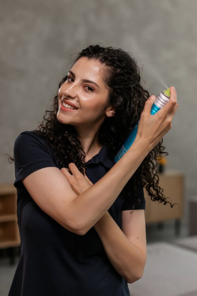 Woman in Black Shirt Spraying Hair Spray