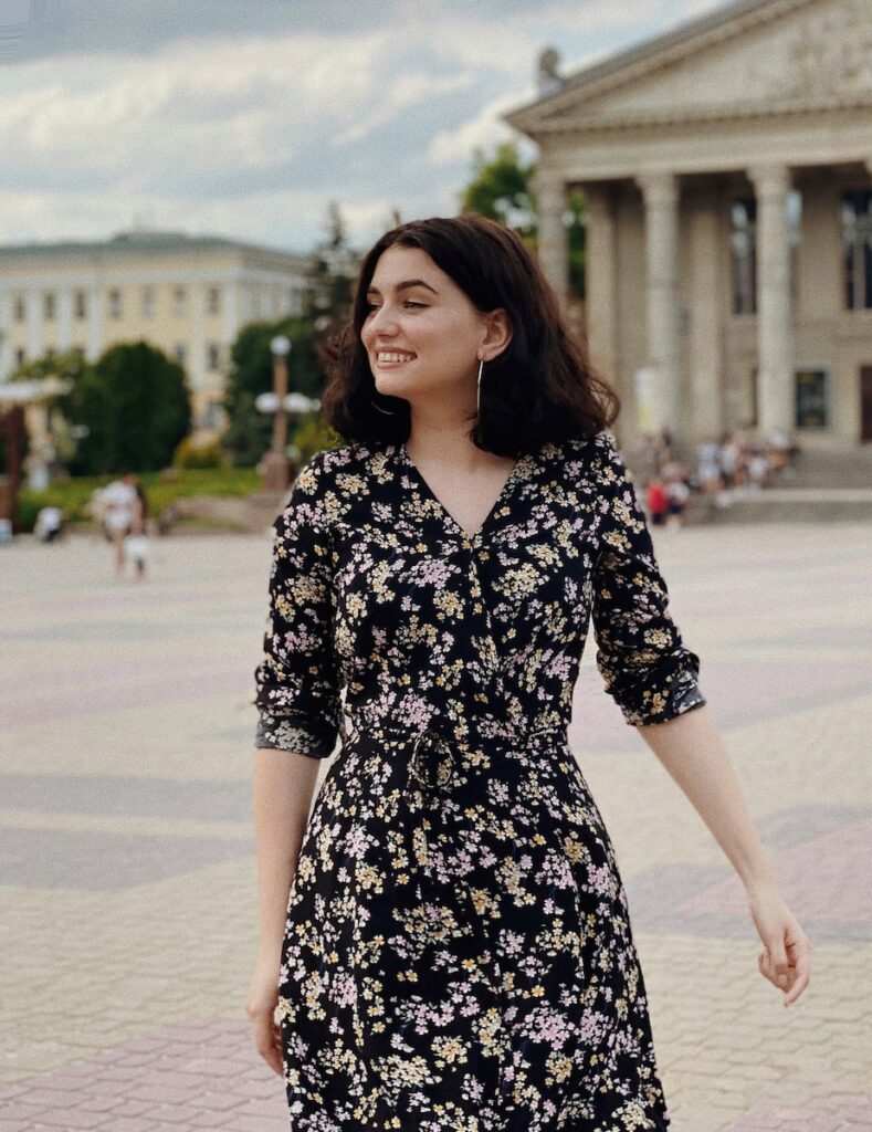 woman in black and white floral dress standing on gray concrete road during daytime