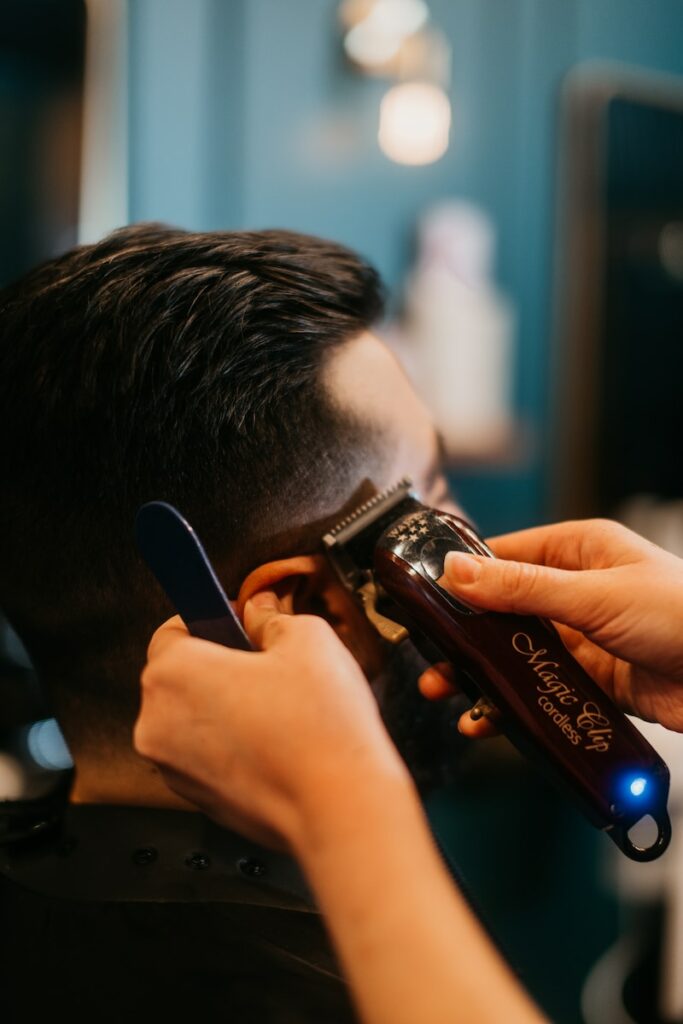 a man getting his hair cut by a hair stylist
