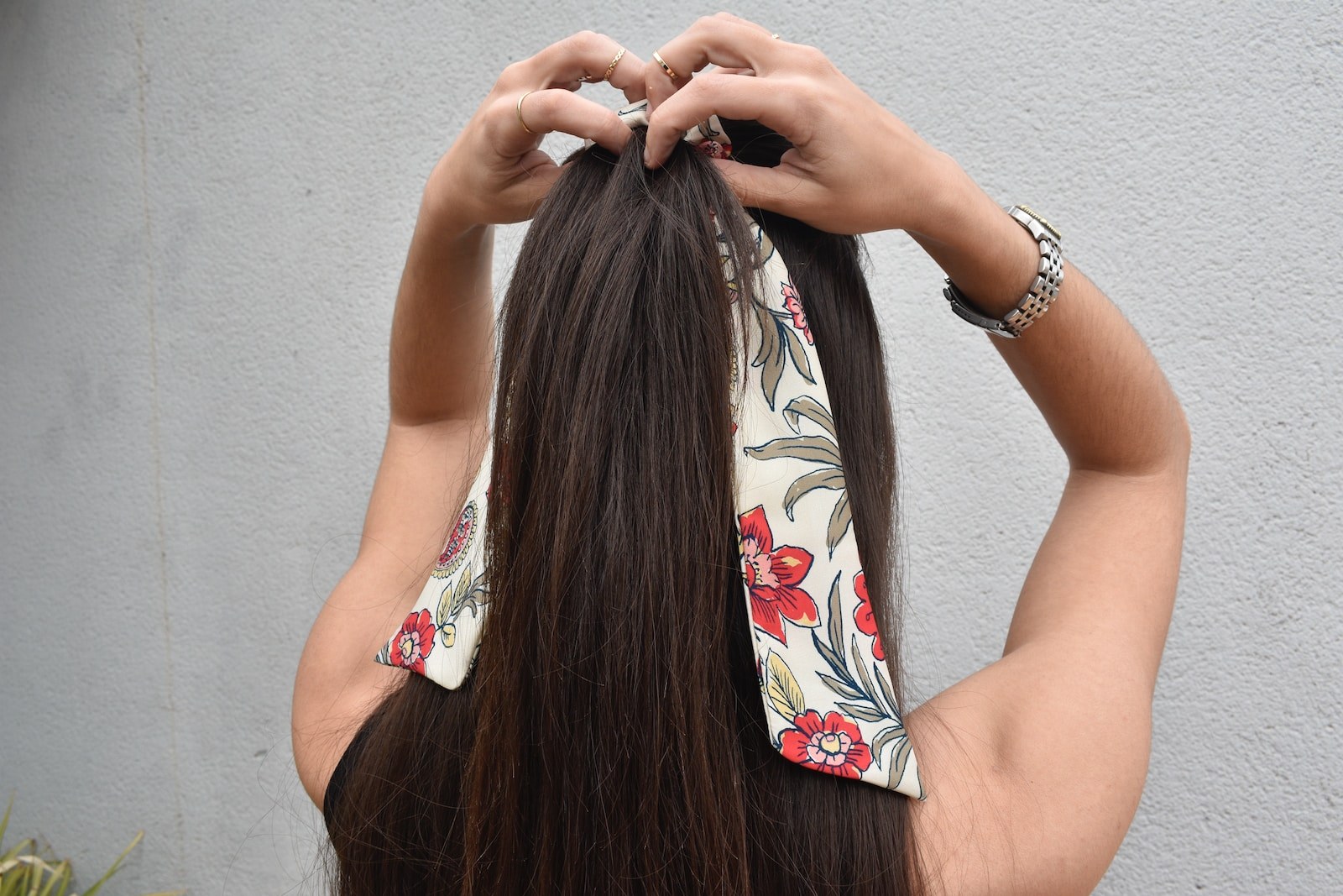 a woman with long hair is putting on a bandana