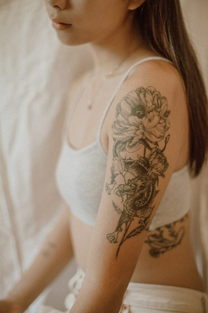woman with black and red rose tattoo on her right arm