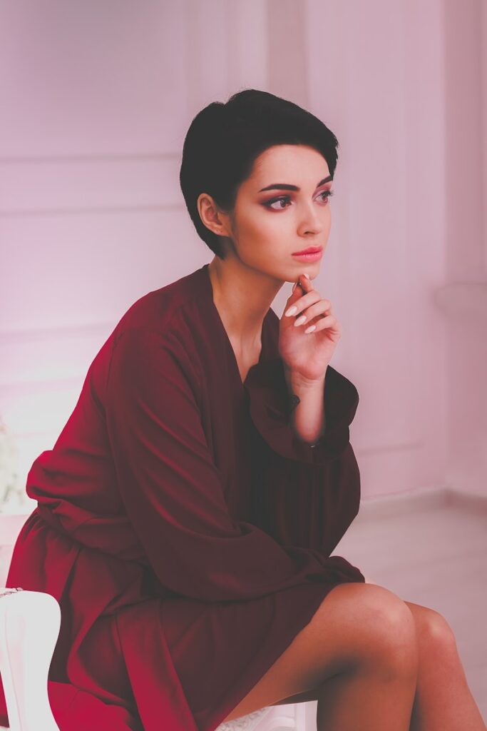 woman sitting on chair with her hand on chin