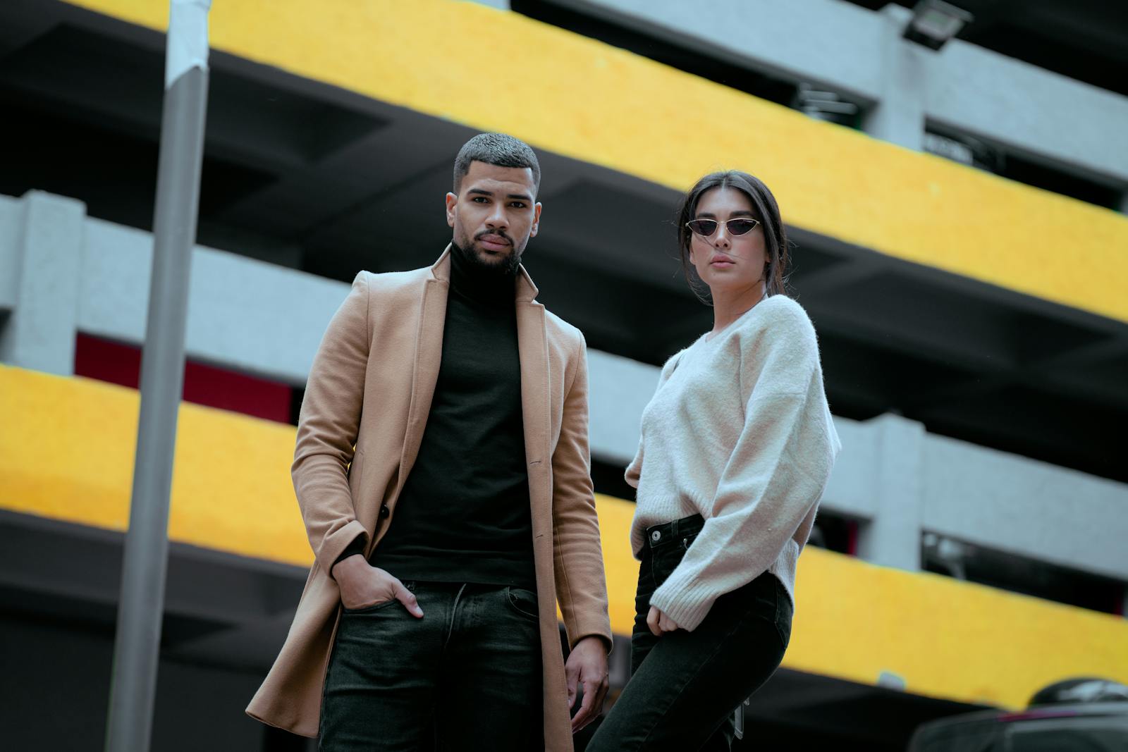 Models in a Beige Coat and White Sweater in front of the Parking Garage